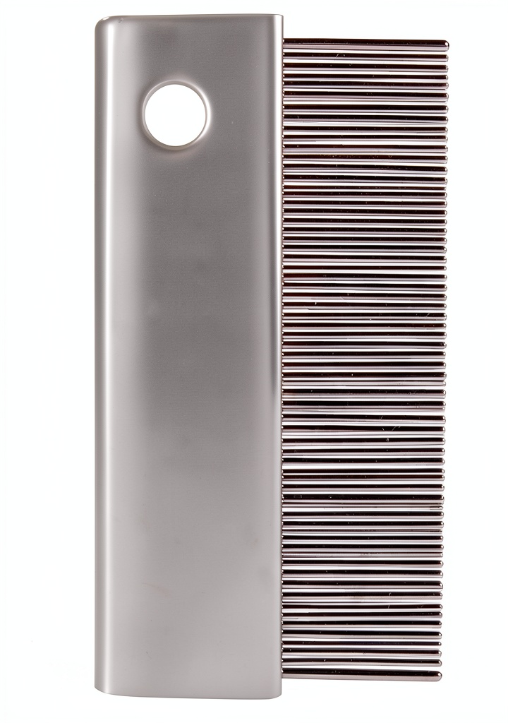 Trixie flea comb being used on a dog in a garden